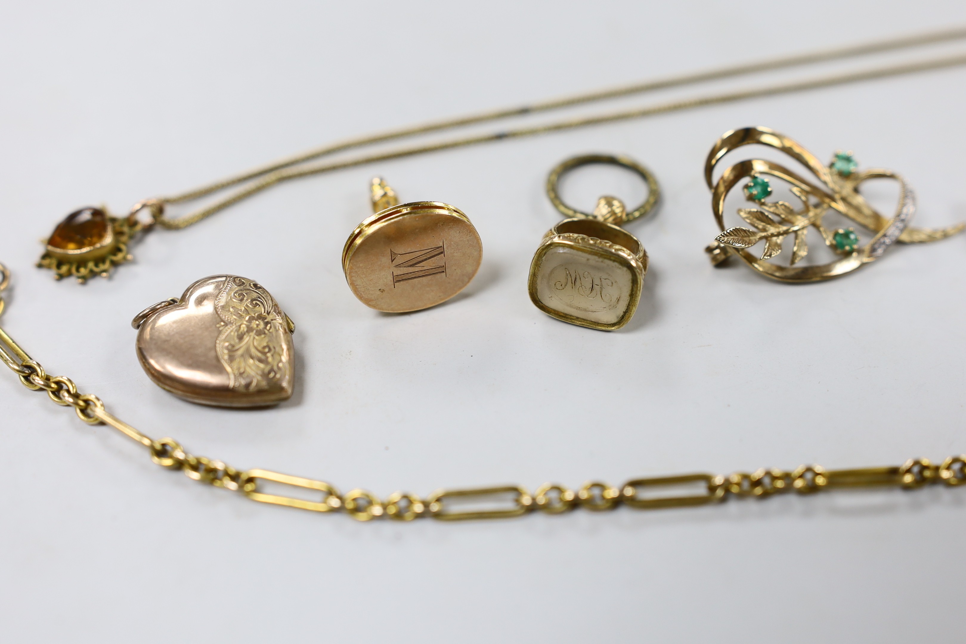 A small collection of Victorian and later jewellery, including two fob seals, two yellow metal charms, a 9ct pendant on a yellow metal chain, mourning pendant, gilt metal albert and a gem set yellow metal foliate brooch.